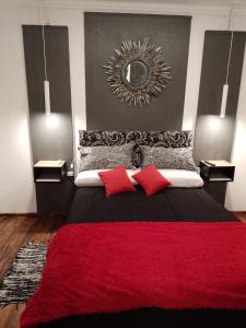 a bedroom with a bed with red pillows and a mirror at B&B - El Refugio -C D in Paraná