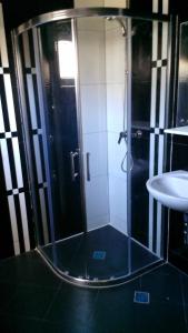 a shower with a glass door next to a sink at Apartments Foco in Sarajevo +35 photos