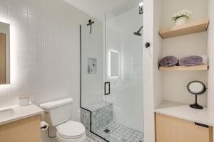 a bathroom with a toilet and a glass shower at Luxe Schweitzer Condo with Hot Tub Ski-InandSki-Out! in Sandpoint +18 photos