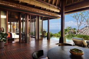 un soggiorno a pianta aperta con tavolo e sedie di Bulgari Resort Bali a Uluwatu
