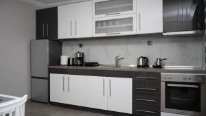 a kitchen with white cabinets and stainless steel appliances at The Patriko - Relaxing Stay with Meteora Views in Kalabaka