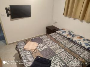 een slaapkamer met een bed en een tv aan de muur bij amir private apartment's in Tel Aviv