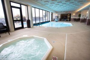 una gran bañera de hidromasaje en una habitación con ventanas en Drury Inn & Suites Champaign, en Champaign