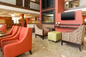 a lobby with chairs and a flat screen tv at Drury Inn & Suites Charlotte University Place in Charlotte