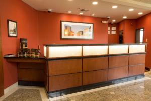 a bar in a hotel lobby with orange walls at Drury Inn & Suites Charlotte University Place in Charlotte