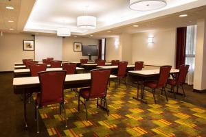 a conference room with tables and chairs and a tv at Drury Inn & Suites Charlotte University Place in Charlotte