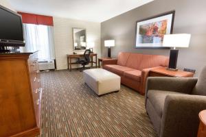 a hotel room with a couch and a tv at Drury Inn & Suites Joplin in Joplin