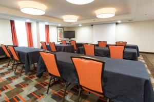 een conferentiezaal met zwarte tafels en oranje stoelen bij Drury Inn & Suites Joplin in Joplin