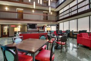 Drury Inn & Suites Houston Galleria في هيوستن: غرفة طعام بها طاولات وكراسي وتلفزيون