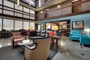 Drury Inn & Suites Houston Galleria في هيوستن: لوبي فيه كنب وطاولات وكراسي