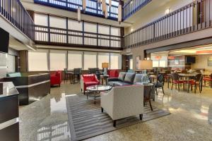 a lobby with tables and chairs and a restaurant at Drury Inn & Suites Houston Sugar Land in Sugar Land
