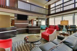 a lobby with a couch and chairs and a television at Drury Inn & Suites Houston Sugar Land in Sugar Land