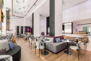 un ristorante con divani, tavoli e sedie di YOTEL Porto a Porto