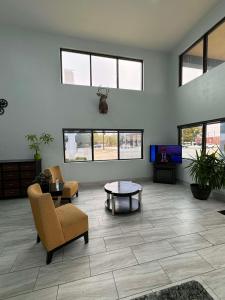 a living room with chairs and a table and windows at SureStay Hotel by Best Western Childress in Childress