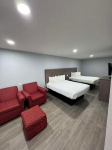 a room with two beds and a couch and chairs at SureStay Hotel by Best Western Childress in Childress