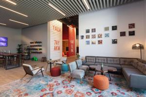 a lobby with a couch and tables and chairs at Rove Trade Centre in Dubai