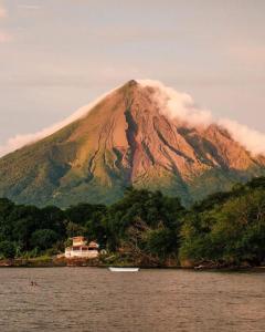 ein Berg mit einem Haus und einem Boot im Wasser in der Unterkunft Hostal Xilotl in San José del Sur