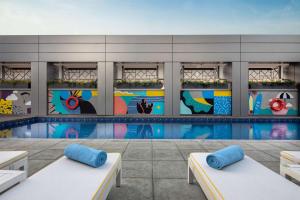a building with a pool with a mural at Rove Dubai Marina in Dubai