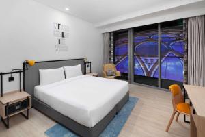 a bedroom with a white bed and a large window at Rove Expo City in Dubai