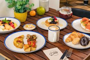 a wooden table topped with plates of breakfast foods at Rove Expo City in Dubai