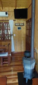 een badkamer met een toilet in een kamer met houten wanden bij Cabaña Guabiroba in Dos de Mayo