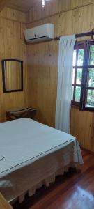 a bedroom with a white bed and a window at Cabaña Guabiroba in Dos de Mayo