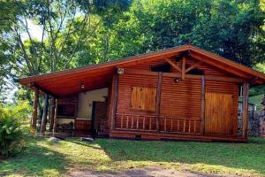 a small log cabin with a porch and trees at Cabaña Guabiroba in Dos de Mayo