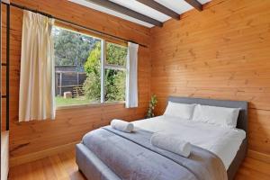 Schlafzimmer mit einem großen Bett und einem Fenster in der Unterkunft Mt Elephant Forrest Cabin 