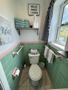 uma casa de banho com WC e azulejos verdes em North Beach Motel em Hampton