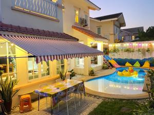 a pool in the backyard of a house with a slide at jomtien pink villa 4BR in Jomtien Beach