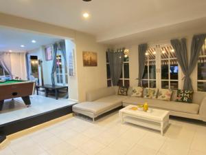 a living room with a couch and a pool table at jomtien pink villa 4BR in Jomtien Beach
