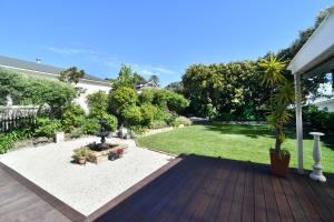 a backyard with a wooden deck and a garden at View 14 in Auckland