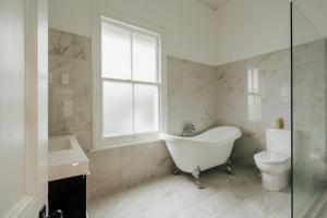 bagno con vasca, servizi igienici e finestra di View 14 ad Auckland