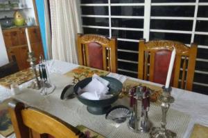 een eettafel met een wit tafelkleed en een kom erop bij Finca Campestre en Guarne in Guarne