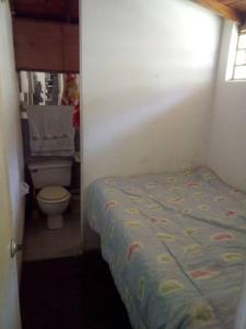 een kleine slaapkamer met een bed en een toilet bij Finca Campestre en Guarne in Guarne