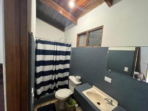 een badkamer met een wastafel, een toilet en een spiegel bij #2 Cabina Rústica para 3 personas en Paquera in Puntarenas