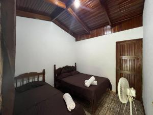 een slaapkamer met 2 bedden en een houten plafond bij #2 Cabina Rústica para 3 personas en Paquera in Puntarenas