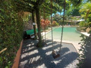 a swing in front of a swimming pool at Diuwak in Dominical