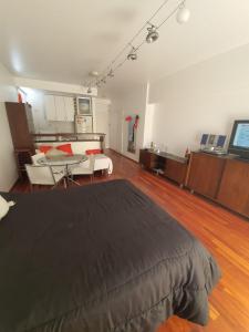 um quarto grande com uma cama e uma mesa em Juncal Apartamento em Buenos Aires