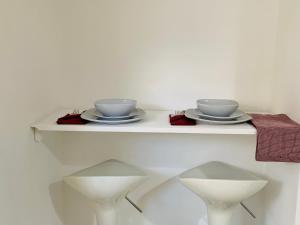 einem weißen Tisch mit zwei Schalen und Platten darauf in der Unterkunft Beautiful, Luxurious 3 Bed house, Perfect for Contractors , Family & Friends in Dartford