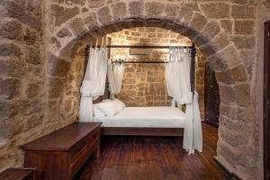 a bedroom with a bed in a stone wall at Saint Michel Boutique Hotel in Rhodes Town