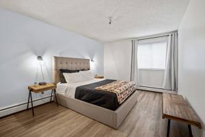 a bedroom with a bed and a large window at Modern 2BR with Free Parking and Newly Renovated in Fort McMurray