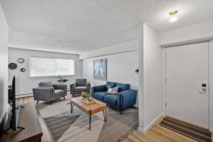 a living room with a blue couch and chairs at Modern 2BR with Free Parking and Newly Renovated in Fort McMurray