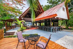 una terraza al aire libre con sillas y un bar en El Sueno Tropical Hotel, en Carrillo