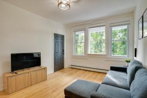 a living room with a couch and a flat screen tv at Modern Hastings-On-Hudson Home Near River! in Hastings-on-Hudson