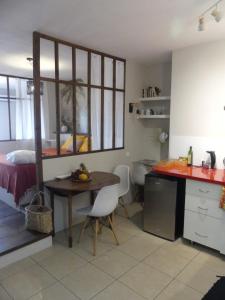 a small kitchen with a table and a bed at Studio Poe Rava in Papeete