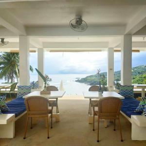 Alon stay في Baras: غرفة بطاولات وكراسي وإطلالة على الشاطئ