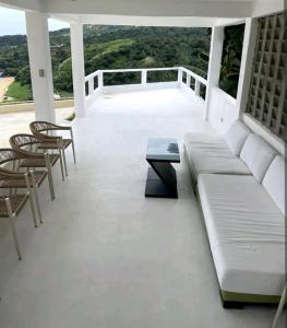 a porch with a couch and chairs and a table at Alon stay in Baras