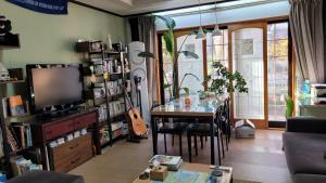 a living room with a table and a television at Tongyeong Episode Guesthouse in Tongyeong