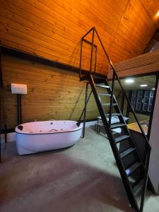 uma banheira num quarto com tecto em madeira em Chalé Panorama em Munhoz